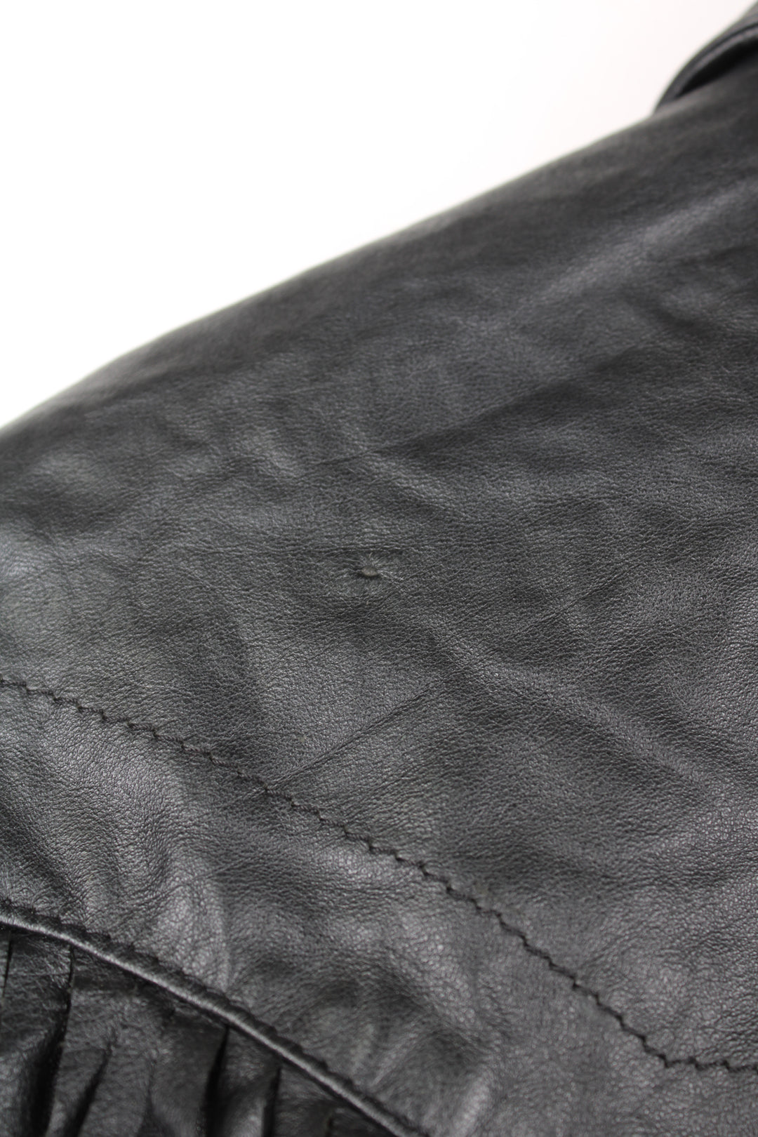 Vintage Wilson's black zip through leather jacket with fringe details on the back of the shoulders and silver conch buttons