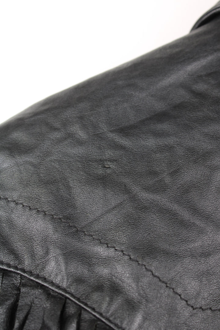 Vintage Wilson's black zip through leather jacket with fringe details on the back of the shoulders and silver conch buttons