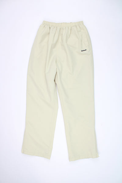 Reebok cream tracksuit bottoms with draw string waist band with zips on the cuffs