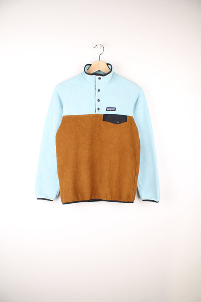 Patagonia Synchilla Fleece in a blue and brown colourway, quarter button up, chest pocket, and has the logo embroidered on the front.