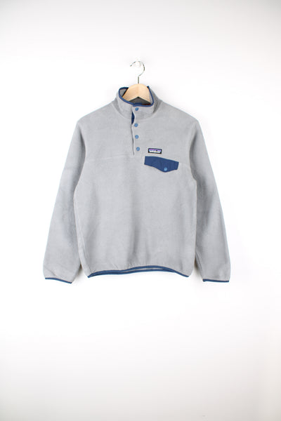 Patagonia Synchilla Fleece in a grey and blue colourway, quarter button up, chest pocket and has the logo embroidered on the front.