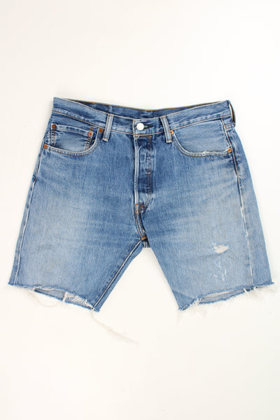 Levi's 501 blue distressed denim jorts with embroidered details on the back pockets and frayed legs