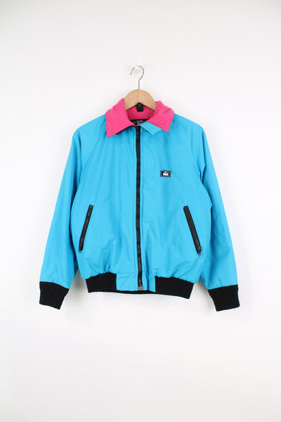 Vintage Woolrich bright blue zip through bomber jacket features black contrast zippers, ,pink fleece lining and logo on the chest