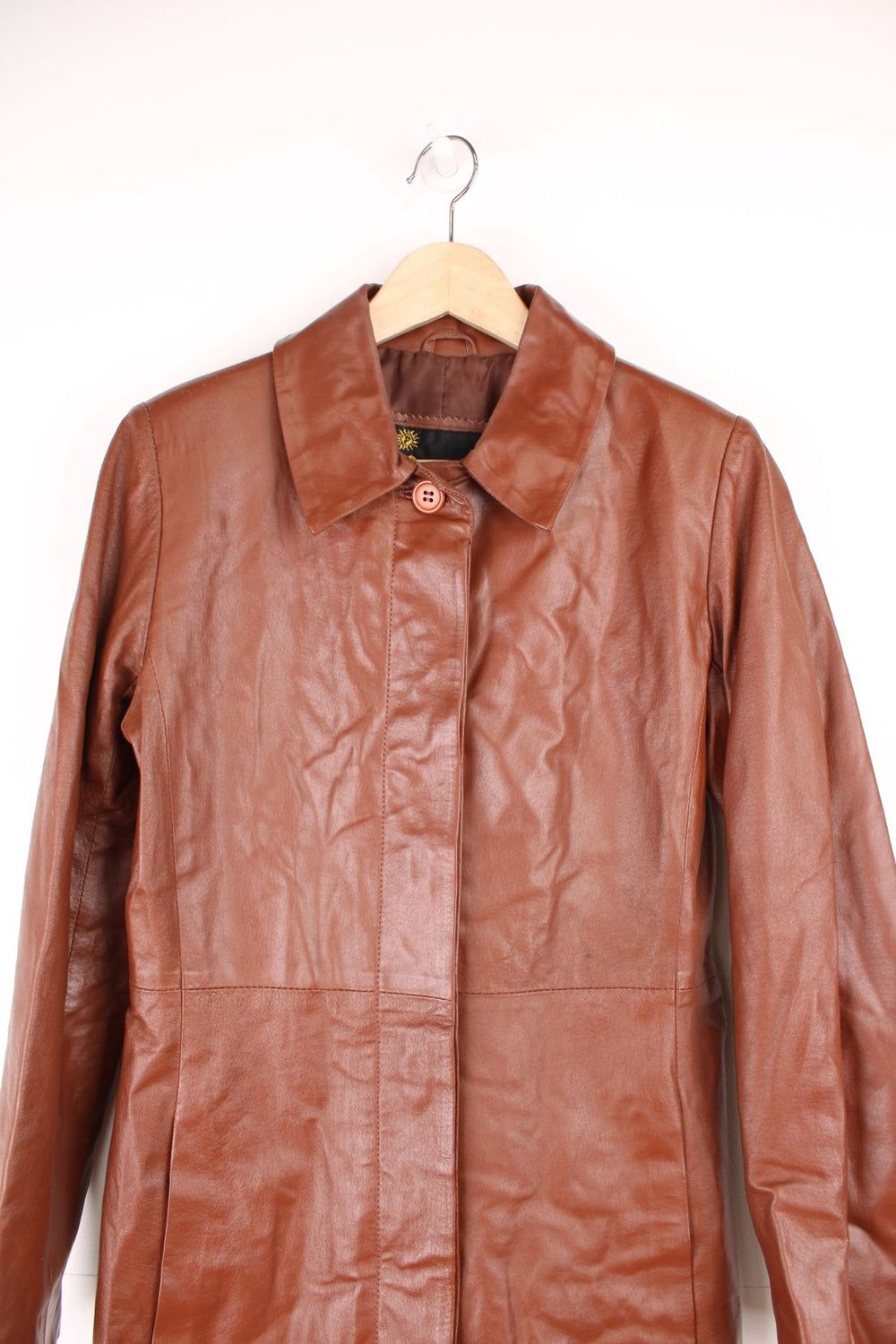 Paragon red-brown leather trench coat with two side slit pockets and concealed button closure.