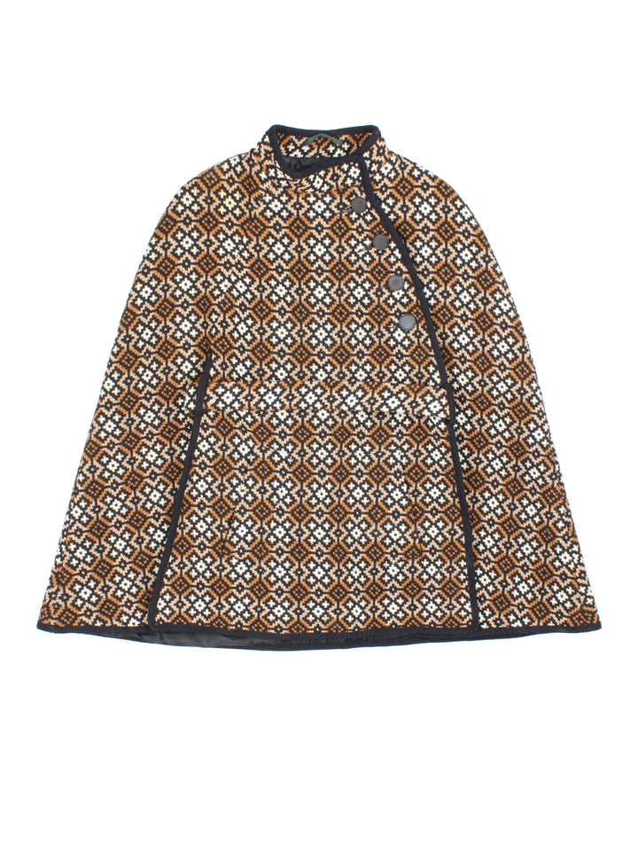 Vintage Welsh Woolen cape in a brown, white and black patterned colourway. Buttons up neckline and is fully lined. Classic double split and belt fastening.