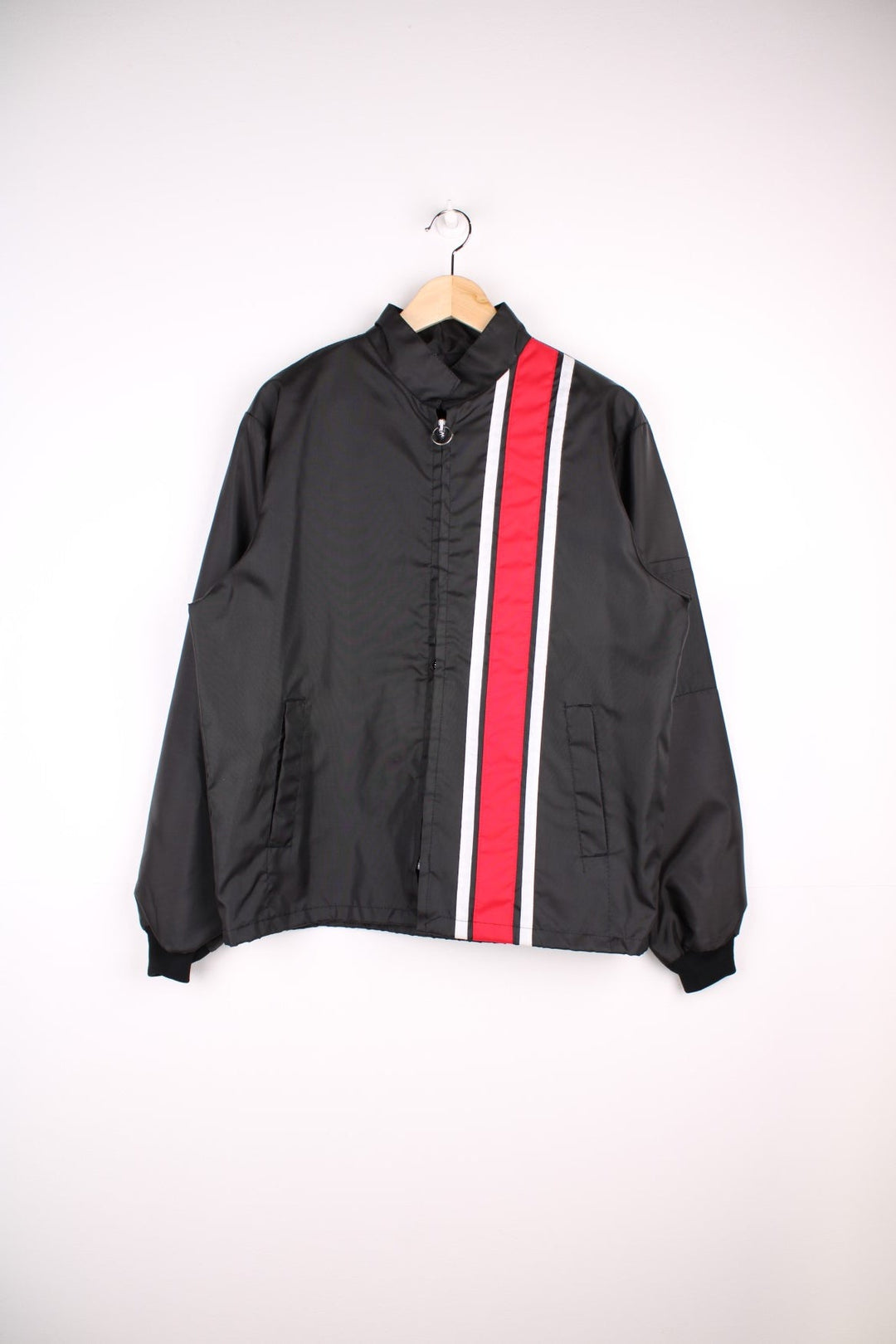 Vintage shell jacket in a black colourway. The jacket has a large printed logo on the back, and from the manufacturing of the jacket seems to date from the late 70s early 80s. Made in the USA.