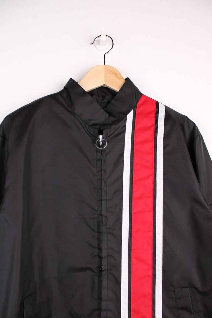 Vintage shell jacket in a black colourway. The jacket has a large printed logo on the back, and from the manufacturing of the jacket seems to date from the late 70s early 80s. Made in the USA.