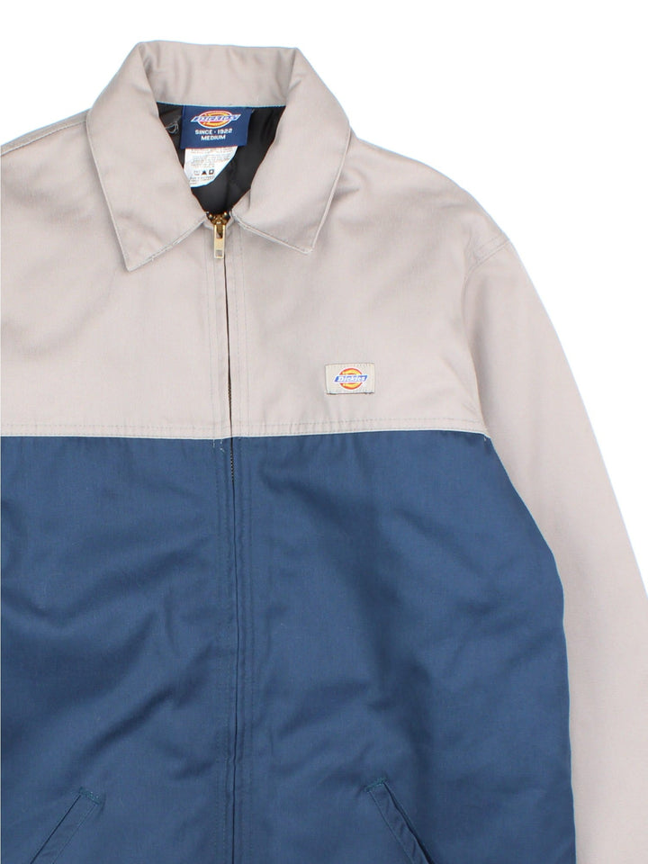 Dickies Eisenhower Jacket in a 2 tone blue and grey colourway. Zips up and has side pockets, insulated with a quilted lining, and has the logo embroidered on the front.