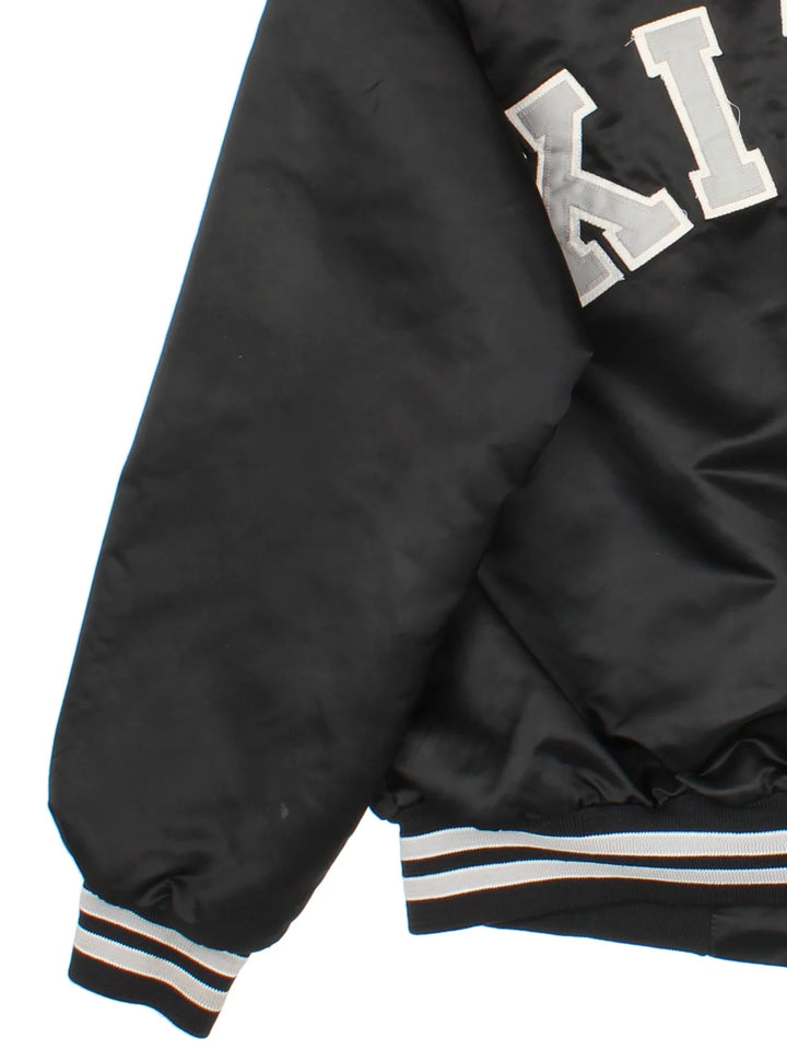 Vintage Los Angeles Kings Varsity Jacket in a black/white colourway. Buttons up with side pockets, contrast cuffs and hem. Logos embroidered on front and back.