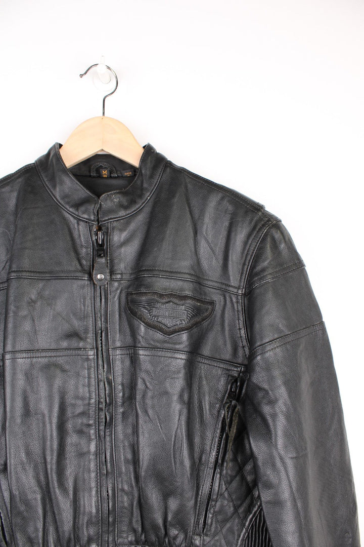 Harley Davidson Motorcycle Jacket in a black colourway, zip up with side pockets, has adjustable waistline buckles, air vent zip on the back, mesh lining, and the logo embroidered on the front and spell out on the back.