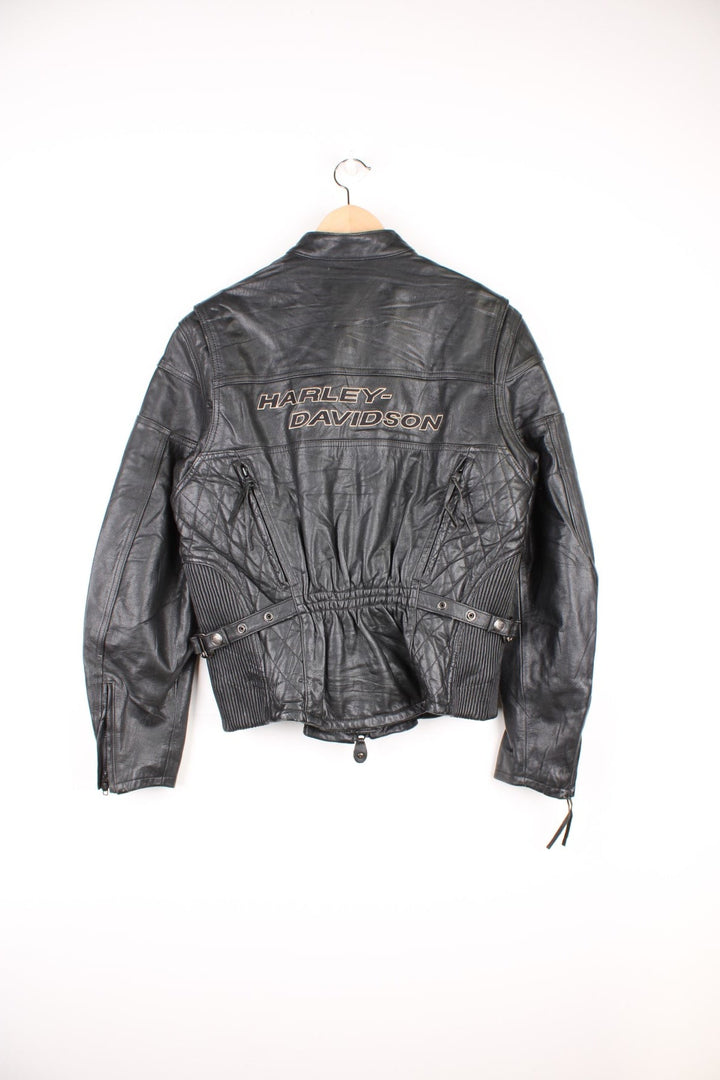 Harley Davidson Motorcycle Jacket in a black colourway, zip up with side pockets, has adjustable waistline buckles, air vent zip on the back, mesh lining, and the logo embroidered on the front and spell out on the back.