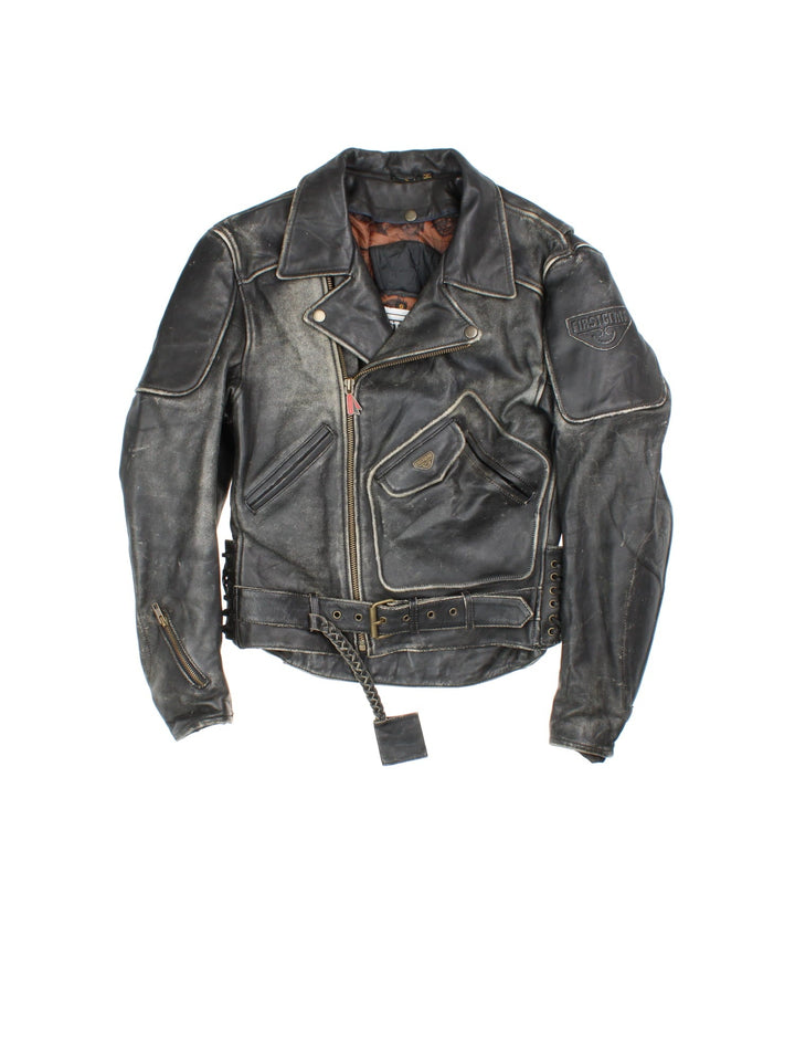 Vintage First Gear Hein Gericke Leather Biker Jacket in a black colourway. Full zip with multiple pockets, Thick padding in elbows and arms, lace up detail on the side with classic emblem on the sleeve.