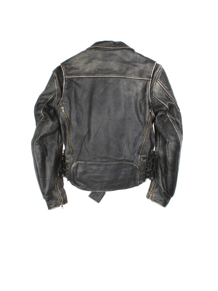 Vintage First Gear Hein Gericke Leather Biker Jacket in a black colourway. Full zip with multiple pockets, Thick padding in elbows and arms, lace up detail on the side with classic emblem on the sleeve.