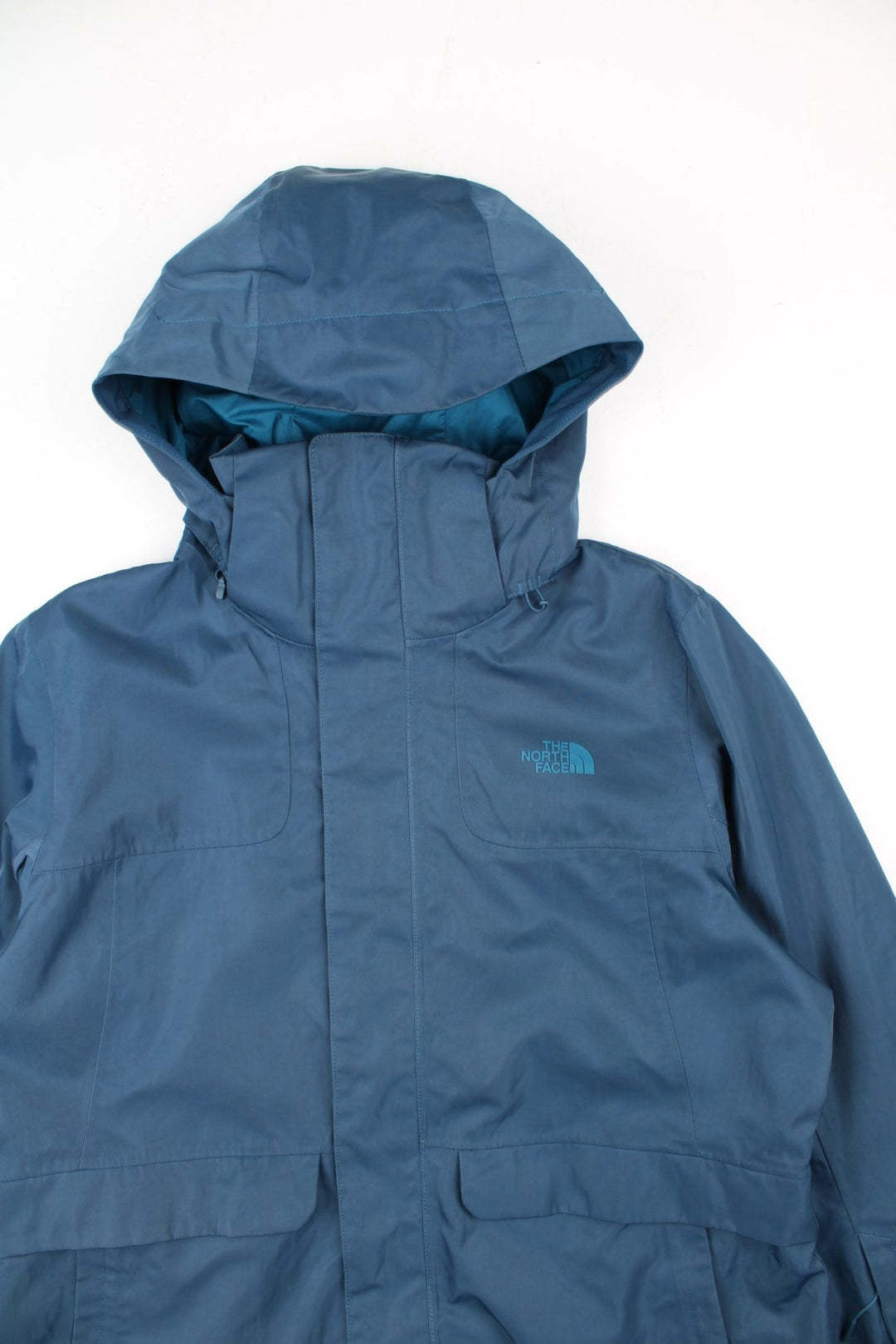 The North Face Dryvent Jacket in a blue colourway. Zips up and has multiple pockets, hooded, and has the logo printed on the front and back.