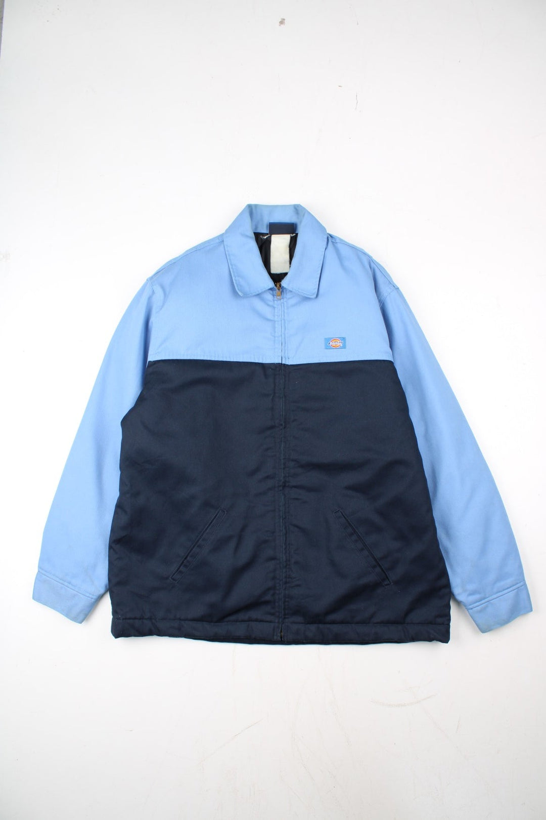Dickies Eisenhower Jacket in a 2 tone blue colourway. Zips up and has side pockets, insulated with a quilted lining, and has the logo embroidered on the front.