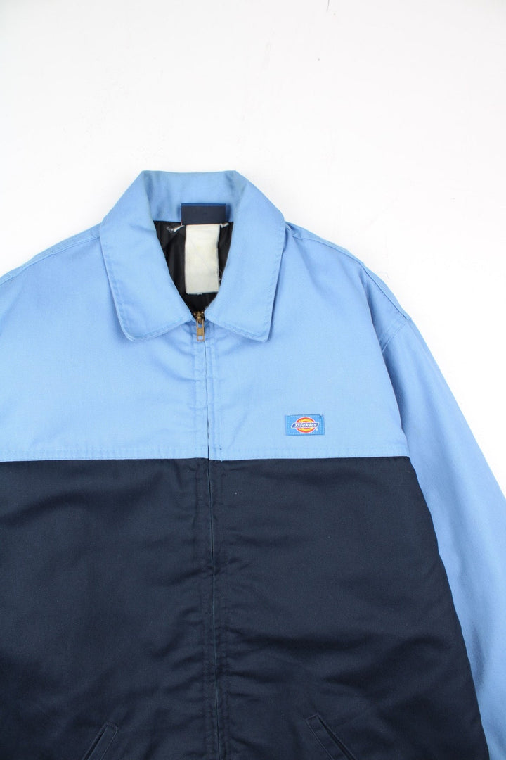 Dickies Eisenhower Jacket in a 2 tone blue colourway. Zips up and has side pockets, insulated with a quilted lining, and has the logo embroidered on the front.