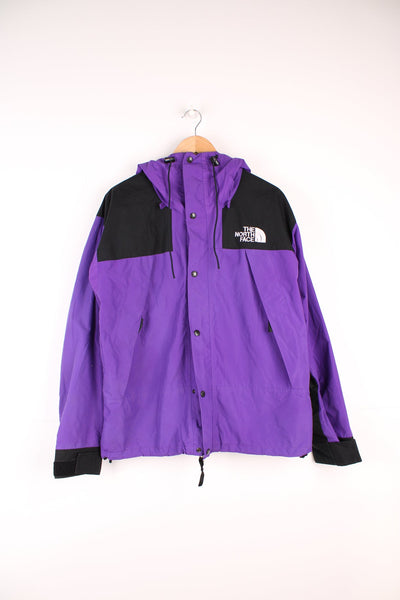 The North Face black and purple zip through hooded rain jacket with embroidered logo on the chest.