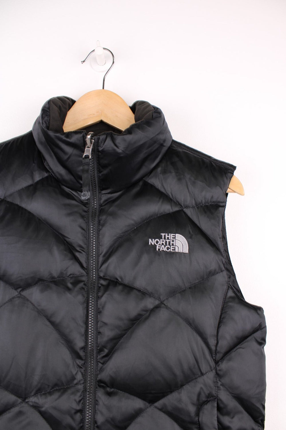 The North Face 550 all black double pocket satin gilet with embroidered logo on the front and back