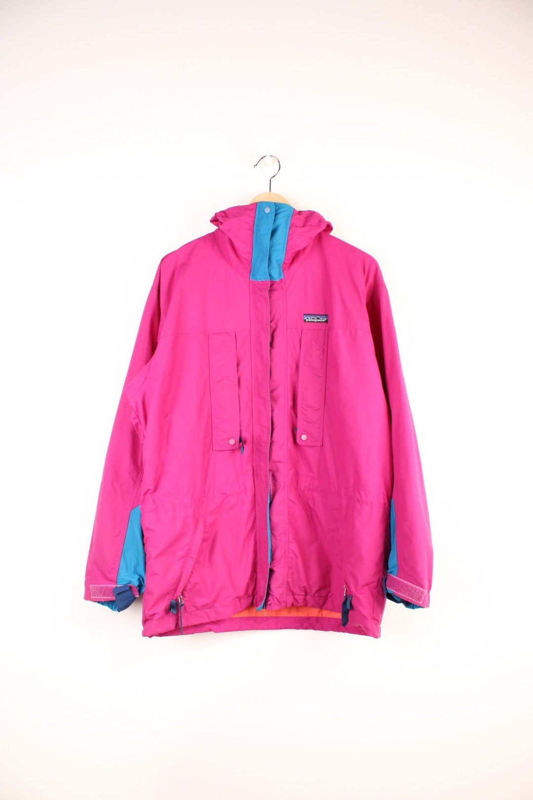 Vintage Patagonia Jacket in a pink and blue colourway, zip up with multiple pockets, hooded and has the logo embroiderd on the front.