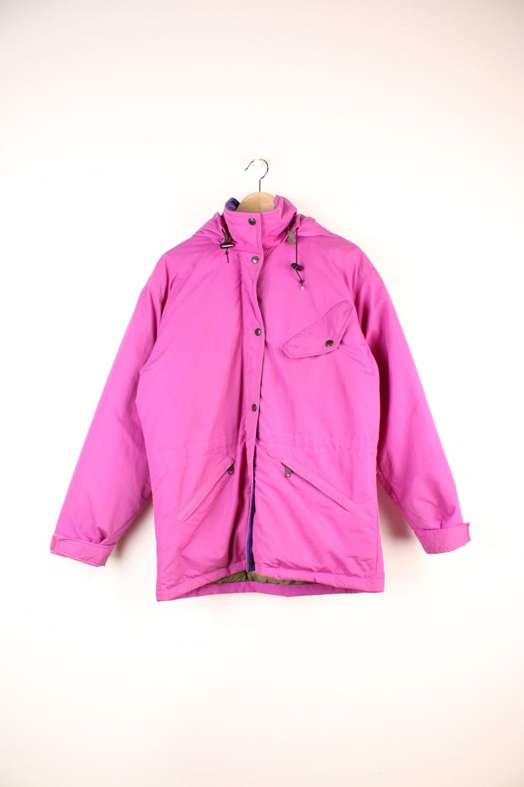The North Face Down Parka Coat in a pink colourway, zip and button up, has a detachable hood, multiple pockets, insulated, and has the logo embroidered on the left sleeve.