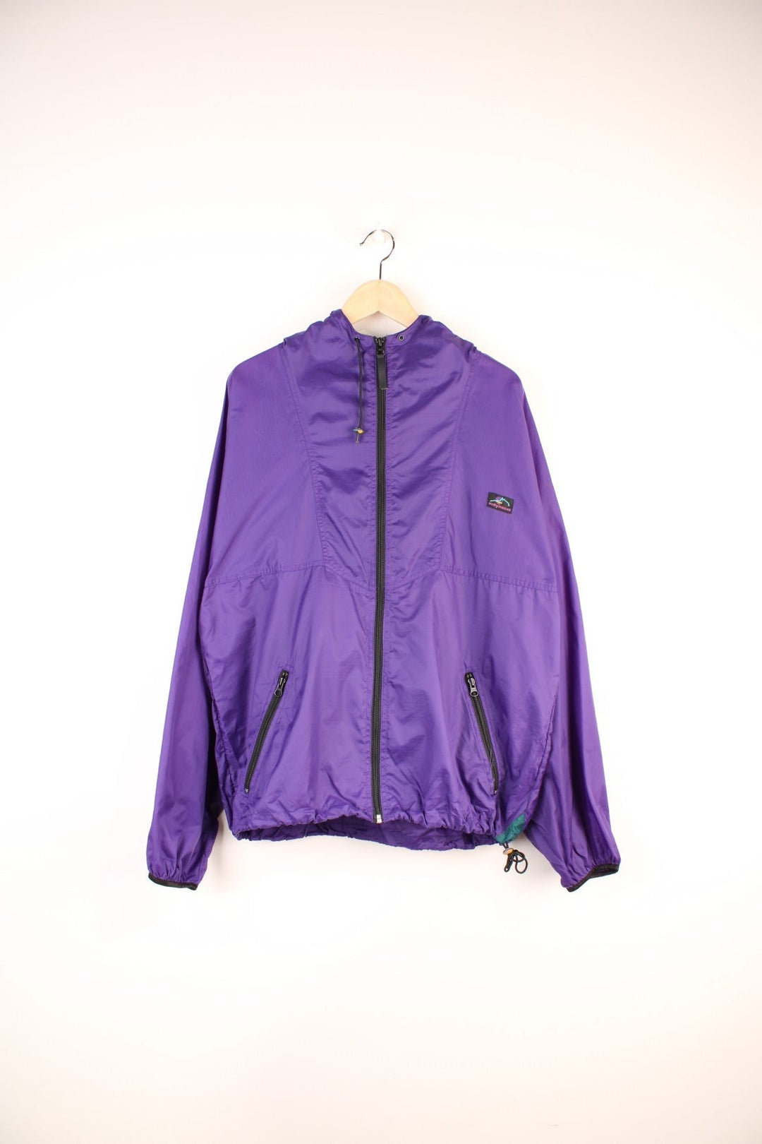 90's Helly Hansen Windbreaker in a purple colourway, zip up with side pockets, hooded and has the logo embroidered on the front.