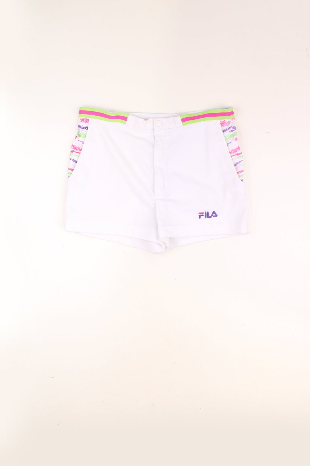 Vintage Fila Tennis Shorts in a white colourway with a multicoloured pattern print by the side pockets, and has the logo embroidered on the front.