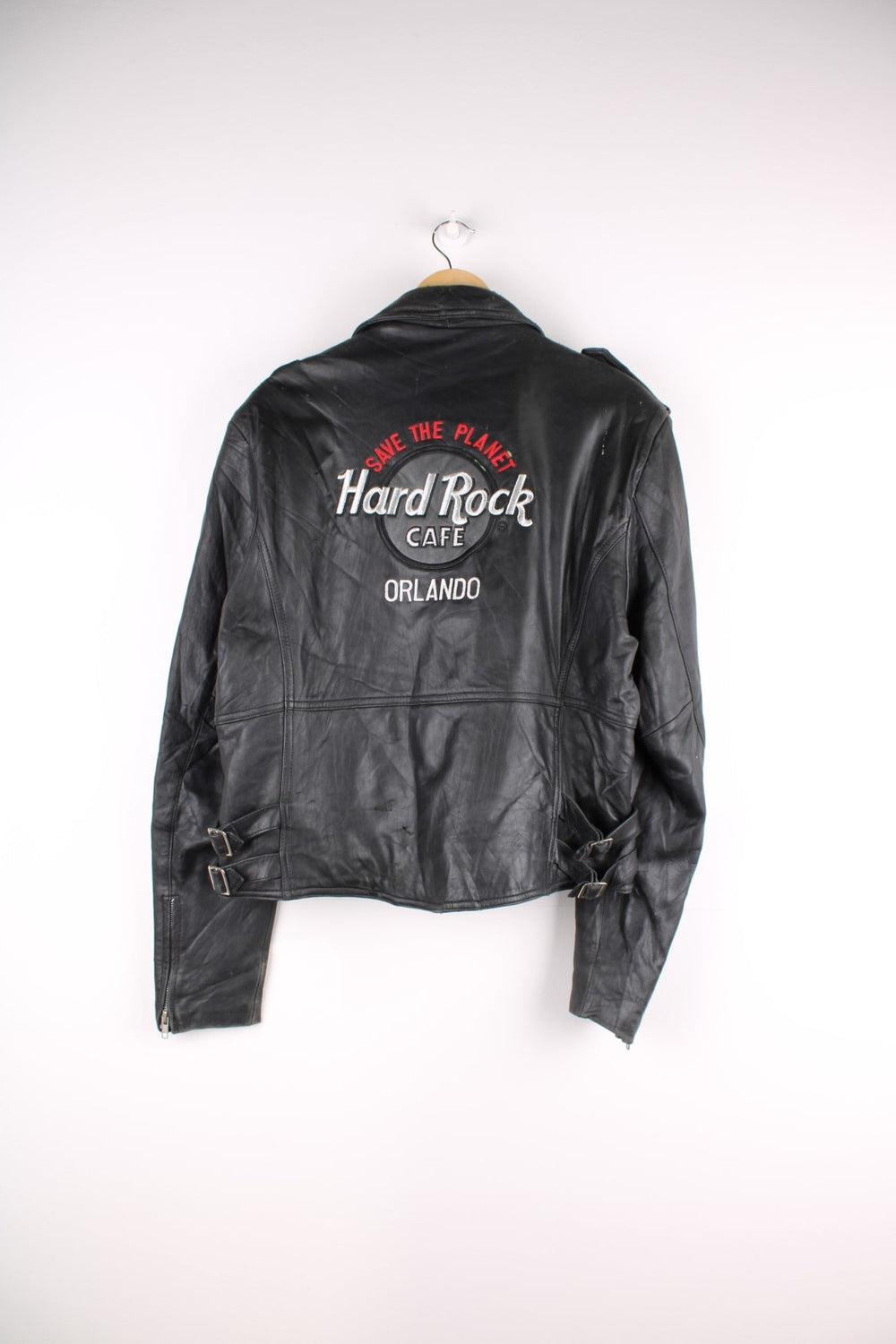Vintage 1990s Hard Rock Cafe Leather Motocycle Jacket in a black colourway. The jacket has a classic motocycle jacket shape, multiple front pockets and a large embroidered patch on the back.