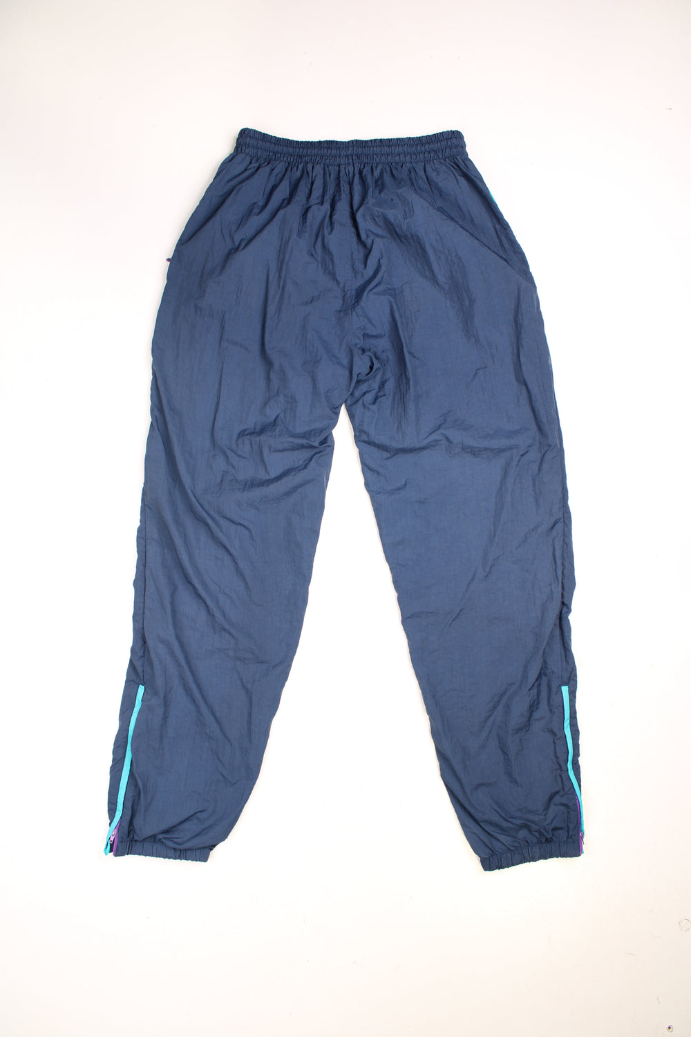 Vintage  Shell Tracksuit Bottoms in a  colourway, has an elasticated waist with drawstring, zip up side pockets, and the logo embroidered in purple on the front.