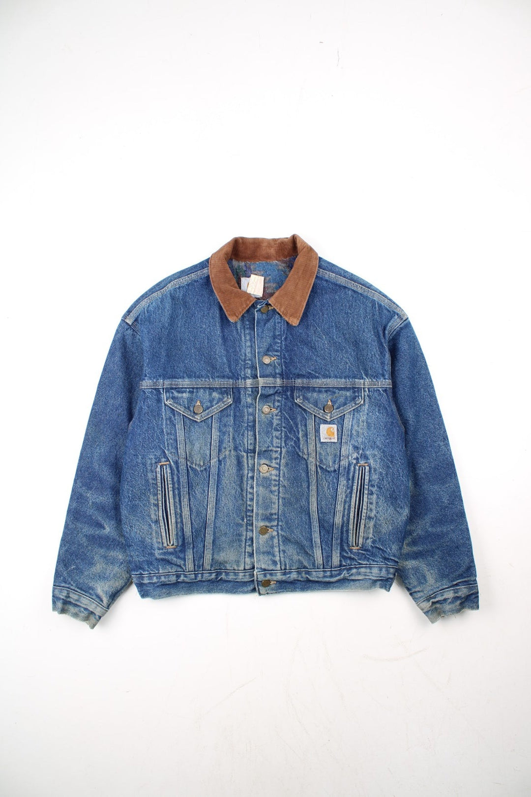 Vintage Carhartt Denim Jacket in a blue colourway with a brown corduroy collar. Buttons up and has multiple pockets, insulated with a blanket lining, and has the logo embroidered on the front.
