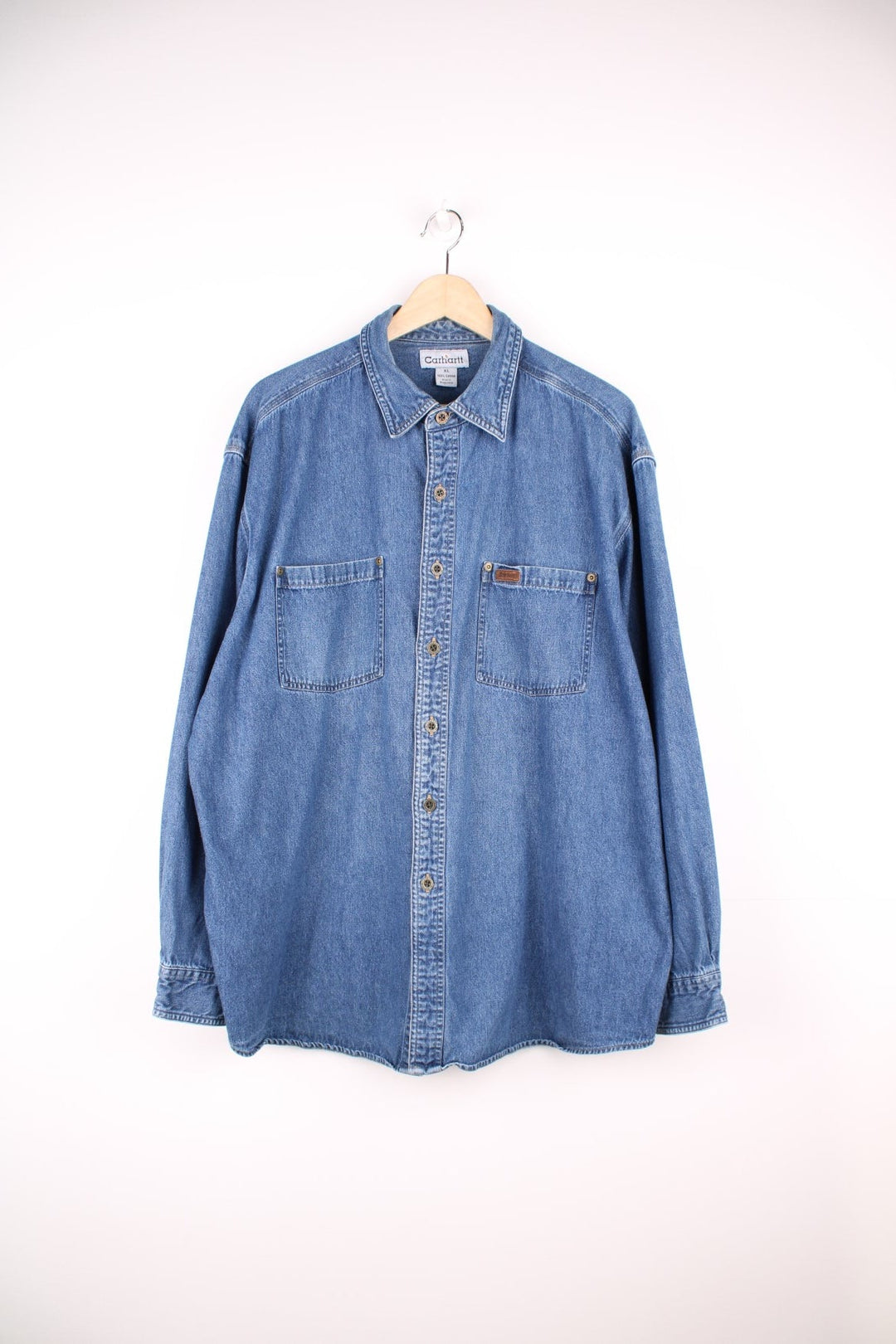 Carhartt button through denim blue denim shirt. Features chest pockets and embroidered leather logo.