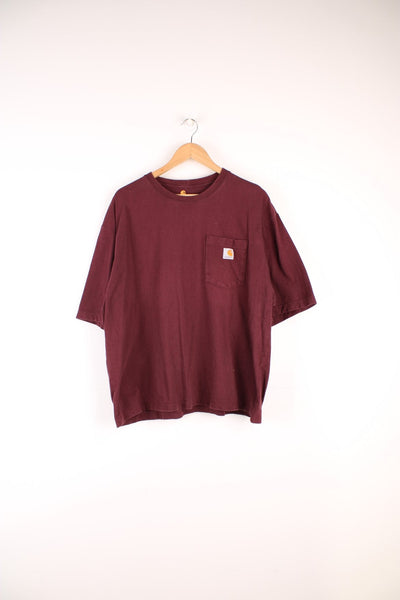 Carhartt T-Shirt in a burgundy colourway, has a chest pocket with the logo embroidered on it. 