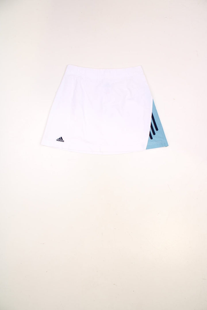 Y2K Adidas mini tennis skirt in white with blue three-stripe design on one side.