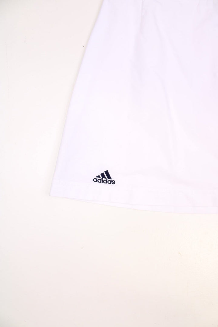 Y2K Adidas mini tennis skirt in white with blue three-stripe design on one side.