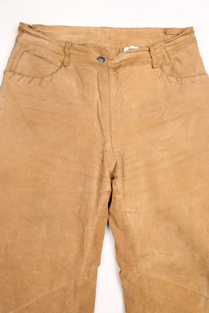 Western Leather Trousers in a  brown colourway with multiple pockets, and has cross stitching tassels down the side of the legs and round the back.