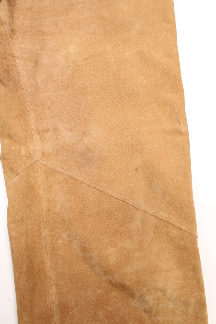 Western Leather Trousers in a  brown colourway with multiple pockets, and has cross stitching tassels down the side of the legs and round the back.