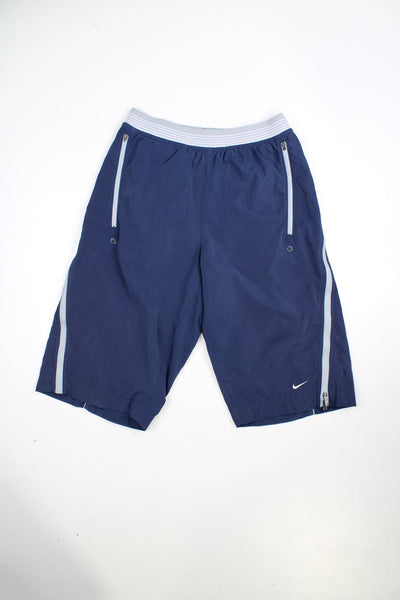 Blue Nike 3/4 length Dri-Fit shorts with elasticated waist. Features zip detail down each leg and embroidered logo.