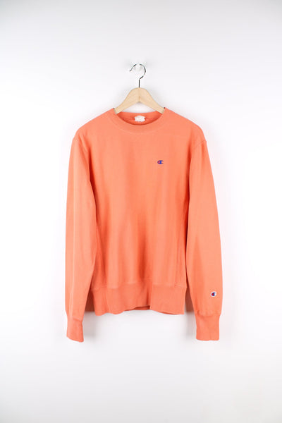Coral pink Champion Reverse Weave sweatshirt featuring embroidered logo on the chest.