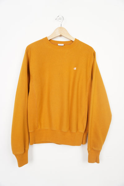 Mustard yellow crew neck Champion sweatshirt with small logo on the chest