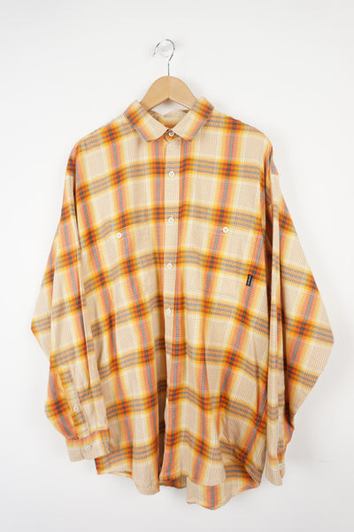 Orange check shirt with embroidered Patagonia label on the pocket.