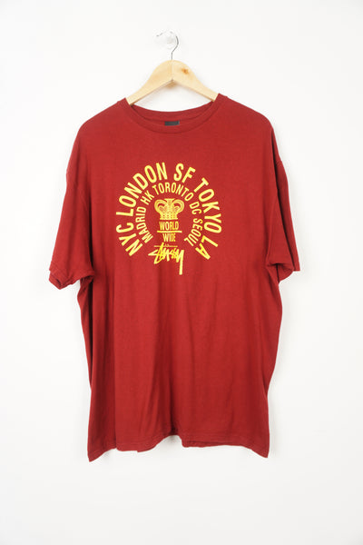 Red Stussy t-shirt with yellow spell-out graphic on the front