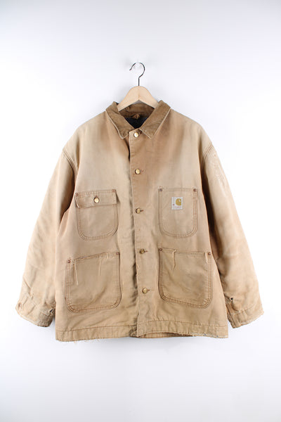 Vintage tan Carhartt distressed chore jacket with corduroy collar, multiple pockets, blanket lining and embroidered logo on the front