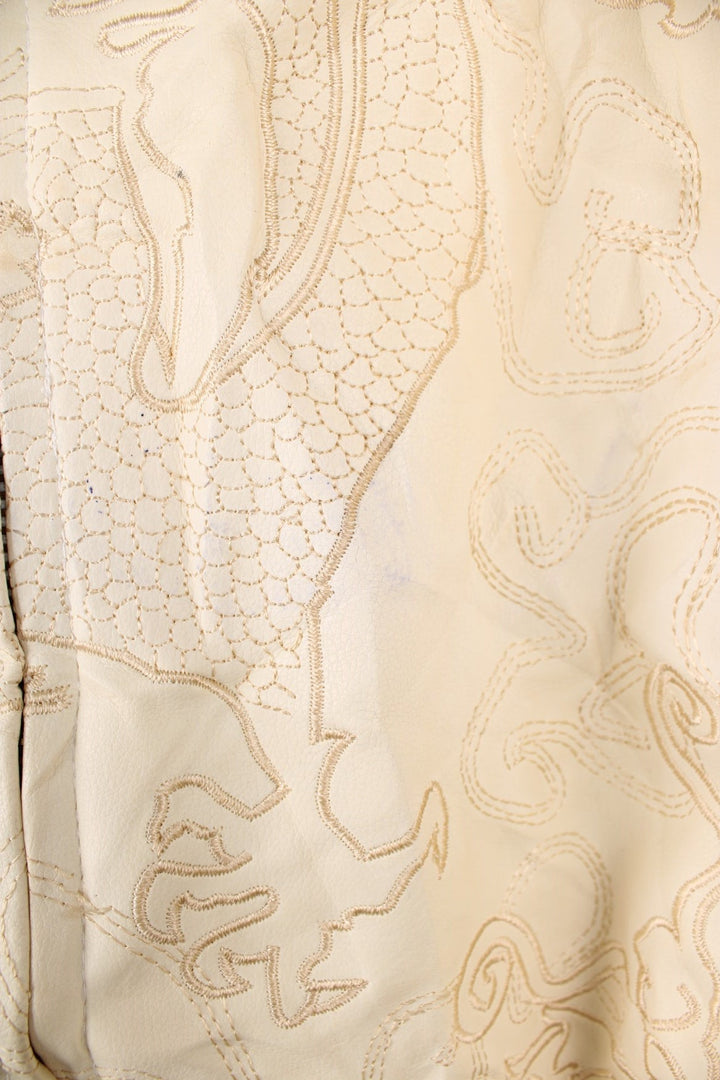 90's Y2K BlueZ Dragon Leather Jacket in a cream colourway, zip up with side pockets, big collar, and has embroidered dragons all over. 