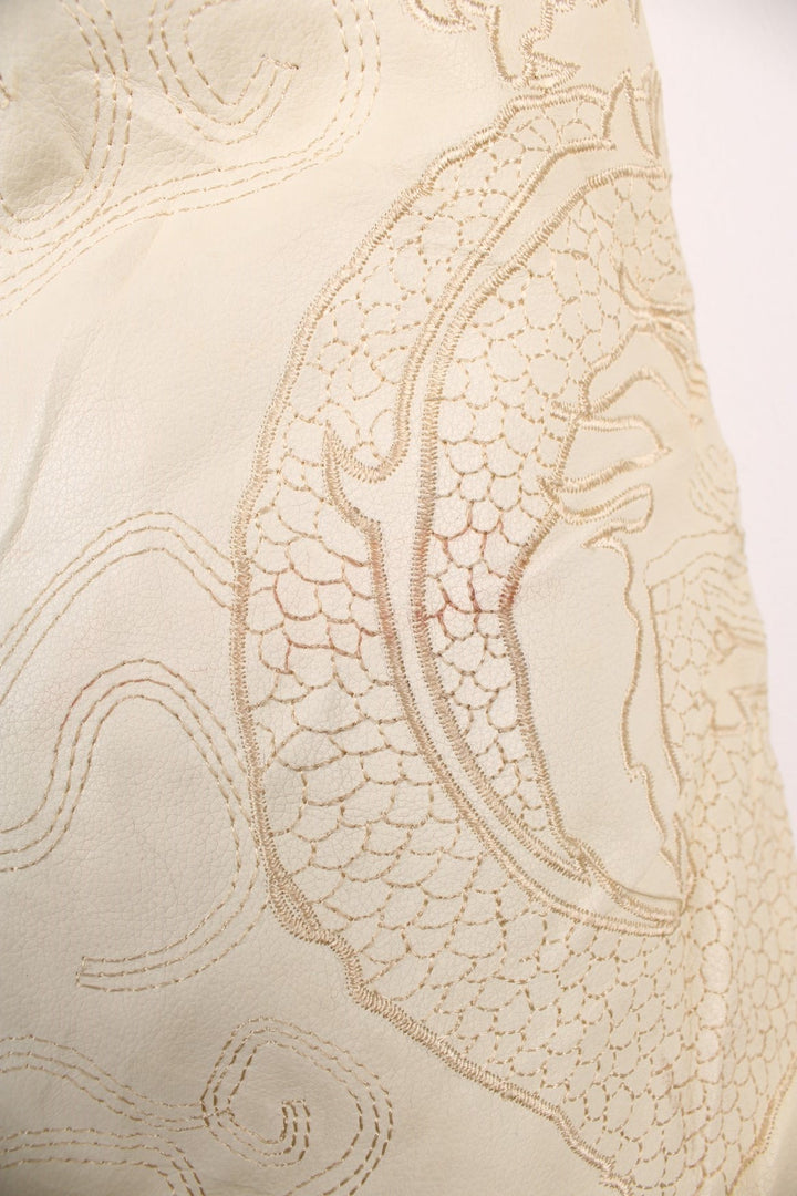 90's Y2K BlueZ Dragon Leather Jacket in a cream colourway, zip up with side pockets, big collar, and has embroidered dragons all over. 