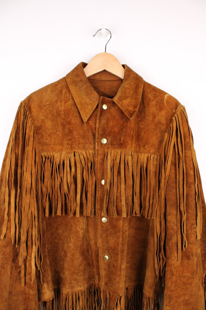 70's Suede Western Fringe Jacket in a brown colourway, button up with double chest pockets, dagger collar, and has tassels all around. 