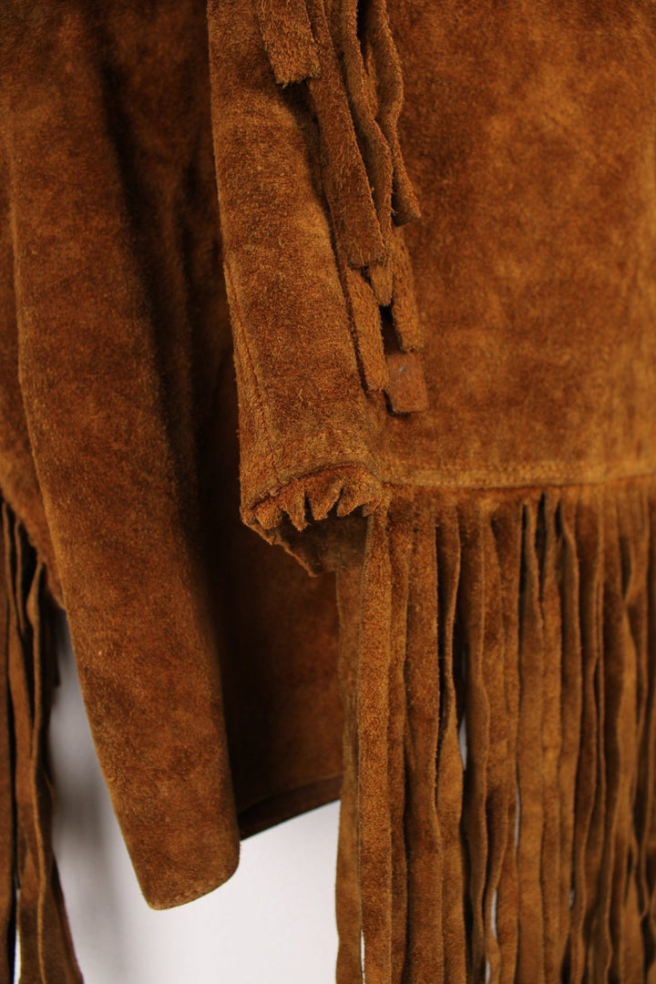 70's Suede Western Fringe Jacket in a brown colourway, button up with double chest pockets, dagger collar, and has tassels all around. 