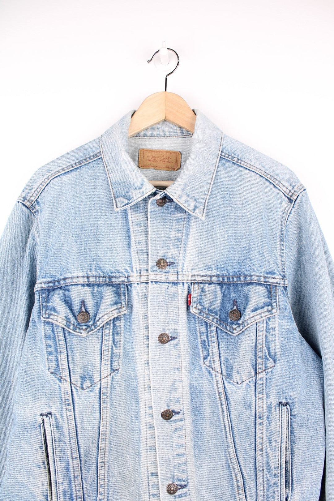Vintage Levi's light wash denim jacket with four front pockets, Levi's branded button closure and a red tab. 