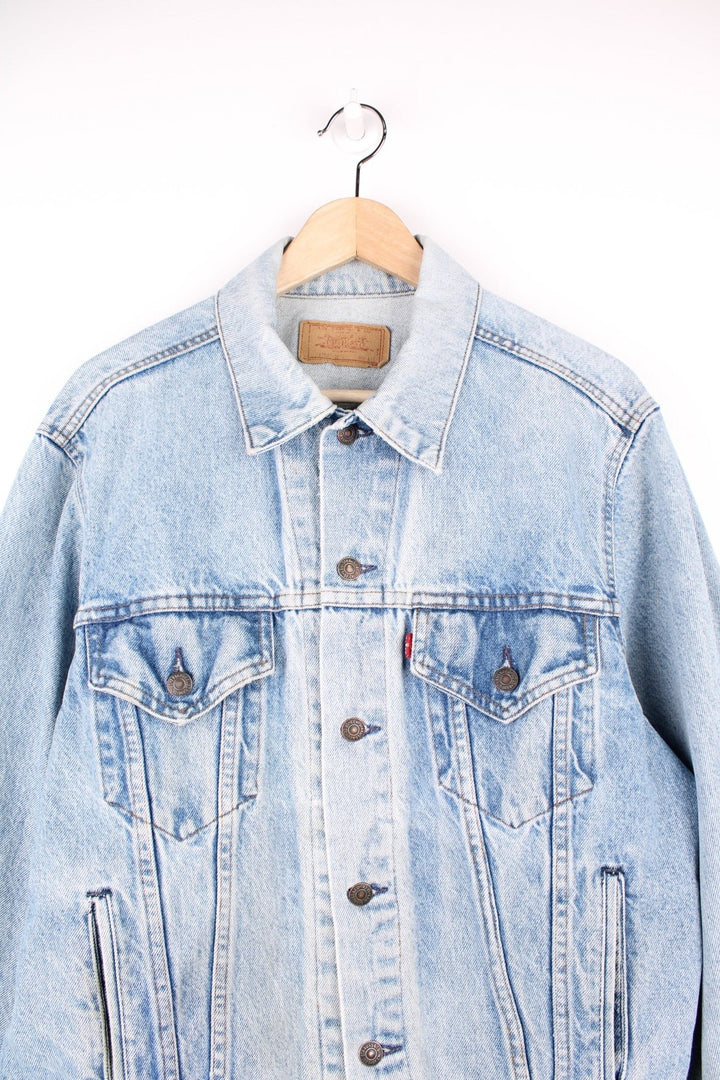 Vintage Levi's light wash denim jacket with four front pockets, Levi's branded button closure and a red tab. 