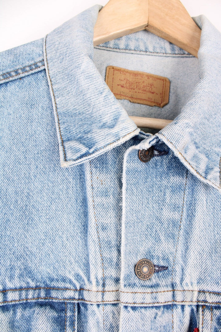 Vintage Levi's light wash denim jacket with four front pockets, Levi's branded button closure and a red tab. 