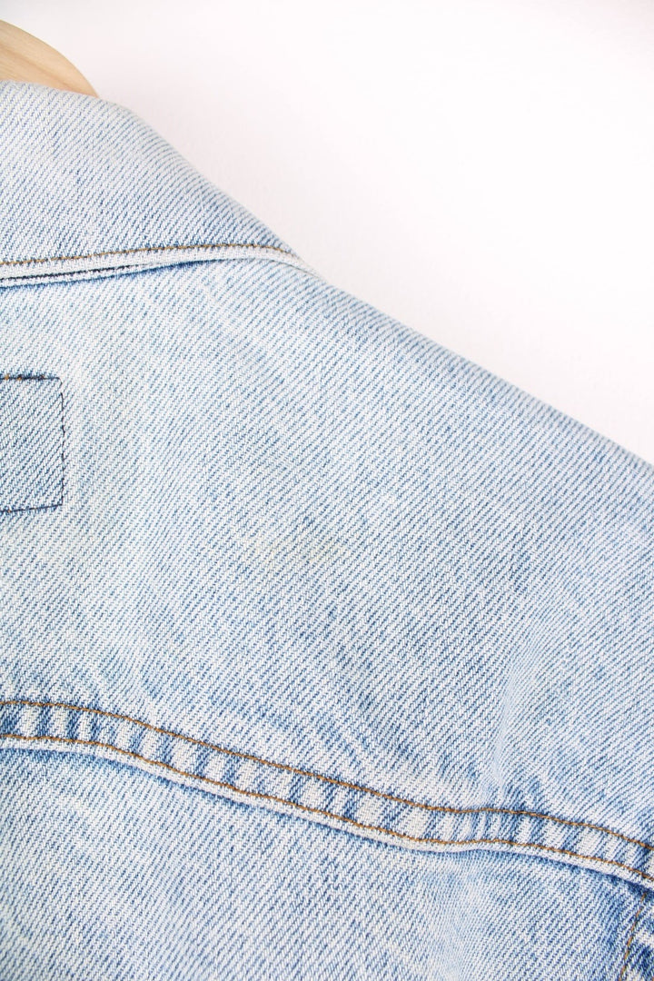 Vintage Levi's light wash denim jacket with four front pockets, Levi's branded button closure and a red tab. 