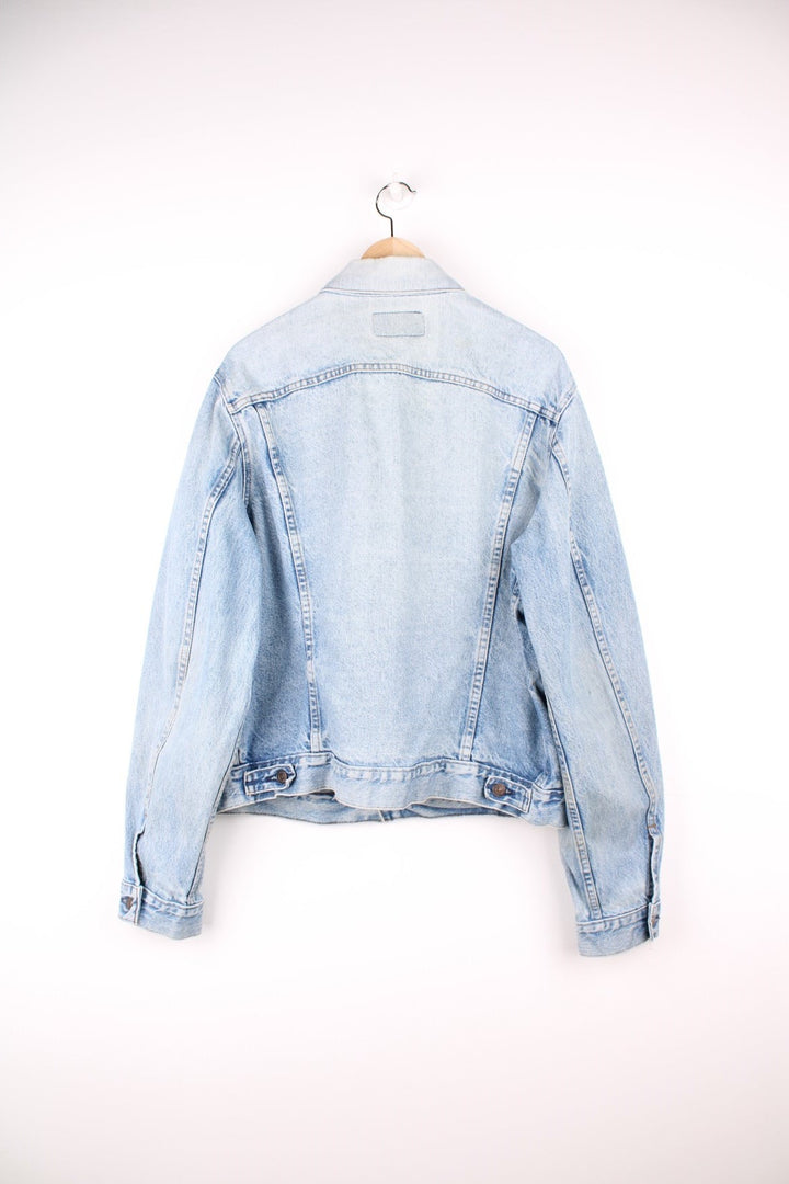 Vintage Levi's light wash denim jacket with four front pockets, Levi's branded button closure and a red tab. 